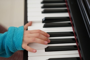 Fototapeta na wymiar Children's fingers on the keys of a piano playing