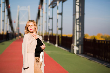 Outdoor street portrait of beautiful model in autumn casual apparel walking in the city