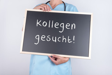 Arzt mit Schild Kollegen gesucht