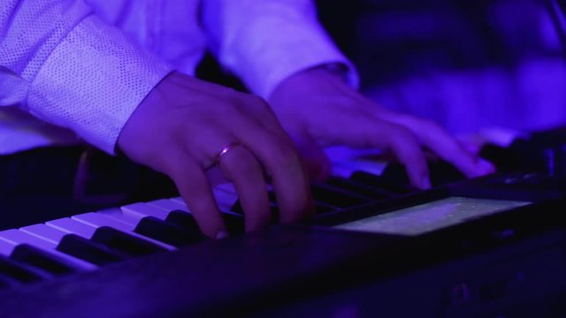 Closeup shot of keyboardist male hands playing synthesizer at party. 4k UHD video.