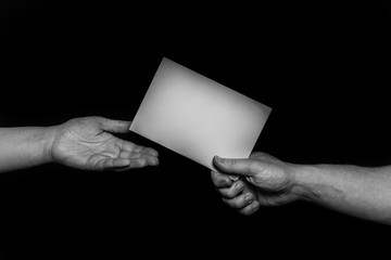 helping hands, offering care, and support. A man's hand holding a card giving it to another person,...