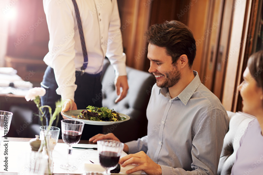 Wall mural romantic couple dating in restaurant being served by waiter