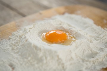 Close up of egg yolk in flour on cutting board