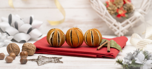 Dried Oranges and Cinnamon on Red Linen Alongside Christmas Ornaments