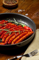 Wiener Sausages in a pan on wooden background