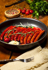 Wiener Sausages in a pan on wooden background