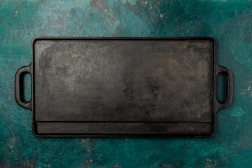 Empty cast iron frying board. Food cooking background. Copy space
