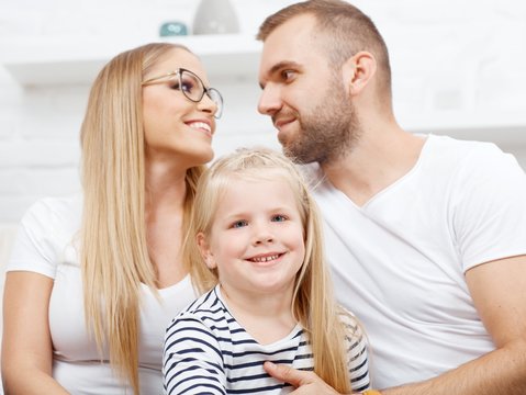 Happy family at home in love kissing child