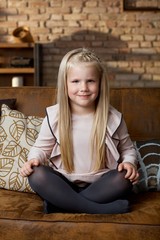 Cute happy child sitting on couch at home