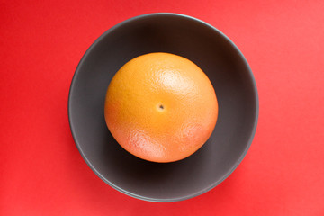 Grapefruit in a plate on a red background