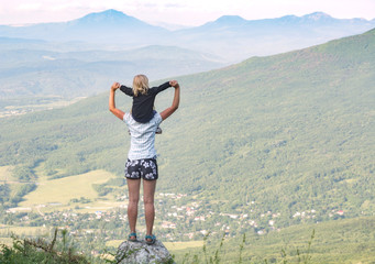 Fototapeta premium Mother keeps the child on her shoulders