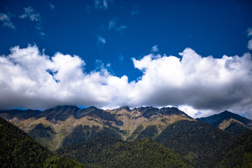 Obraz premium large dense mountain against a blue sky with clouds