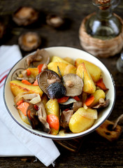 Fototapeta na wymiar Stewed potatoes with onion, mushrooms, carrot, rosemary and garlic in olive oil.