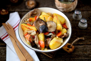 Fototapeta na wymiar Stewed potatoes with onion, mushrooms, carrot, rosemary and garlic in olive oil.