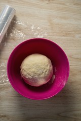 Fototapeta na wymiar Overhead view of dough in pink bowl