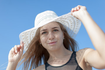 Portrait of young woman in sun hat against sky