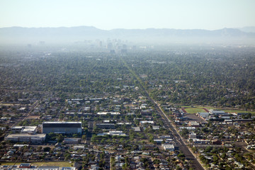 Fototapeta premium Air pollution from Interstate-10 and I-17 in morning haze above major Arizona city downtown of Phoenix as seen from the top of North Mountain Park hiking trails