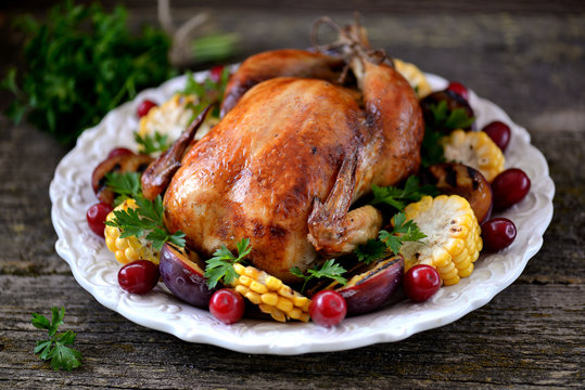 Grilled chicken on Thanksgiving day with corn, plum, dogwood and parsley.