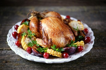 Grilled chicken on Thanksgiving day with corn, plum, dogwood and parsley.