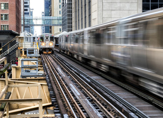 Moving Train on elevated tracks within buildings at the Loop, Glass and Steel bridge between...