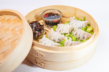 Close up various dim sum and sauce in bamboo steamer on the white background isolated. Chinese...