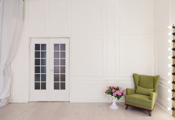 Green Chair in a white room with a door