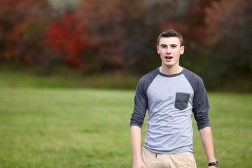 Portrait of a teenage boy walking outdoors during autumn