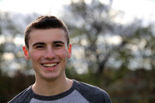 Portrait head shot of a teenage boy smiling