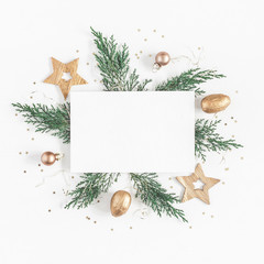 Christmas composition. Paper blank, christmas tree branches, golden decorations on white background. Flat lay, top view, copy space, square