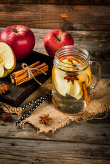 Fall and winter drinks. Autumn detox water with apple, cinnamon and pear in mason jar. On a rustic old wood background, with ingredients. Copy space