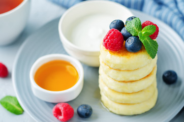 Cottage cheese pancakes with honey, sour cream and berries