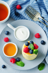 Cottage cheese pancakes with honey, sour cream and berries
