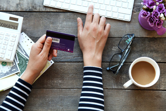 Woman using keyboard and credit card indoors
