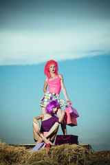 women in colorful wig hair with shopping bag on hay