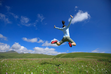 jumping woman have fun in a mountain peak meadow