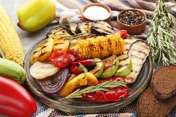 Grilled vegetable on brown cutting board with rosemary