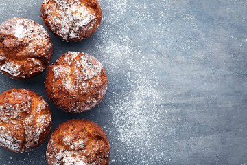 Tasty muffins on grey wooden table