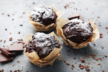 Tasty chocolate muffins on grey wooden table