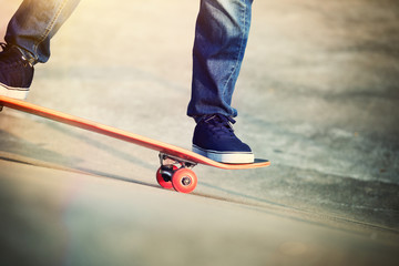 Fototapeta na wymiar skateboarder legs skateboarding on skatepark ramp