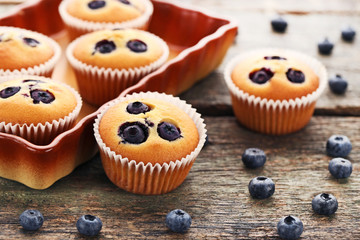 Sweet blueberry muffins on grey wooden table
