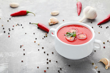 Tomato soup with parsley on grey wooden table