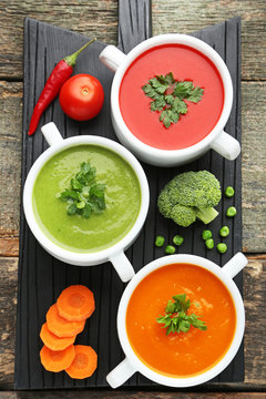 Vegetable cream soup with parsley on black cutting board