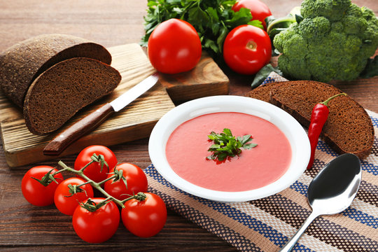 Tomato soup with parsley on wooden table