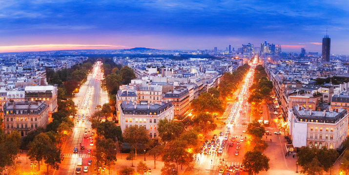 Paris, France. Breathtaking and enchanting panoramic view from Arc Triumph of Paris skyline on twilight autumn scenery of streets and cityscape. Defence district in background. Champs d'Elysee area.