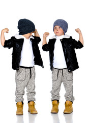 Fototapeta premium Two little boys in black jackets and hats.