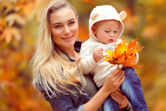 Happy mother with baby in autumn park