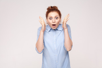 Isolated studio shot on gray background of happy successful young adult redhead woman, feeling lucky, looking at camera, excitement and joy, smiling cheerfully.