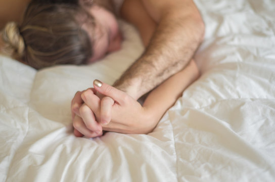 &oacute;timo conceito de orgasmo, sexo, sem vulgaridade, homem segurando m&atilde;o de mulher na cama