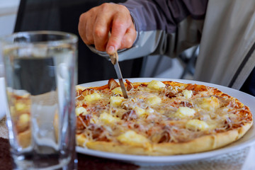 Girl cut pizza on table close up