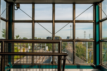 Industrial interior design of glass windows and steel frame. Stairway with glass window panels and steel cables. Train railway station.